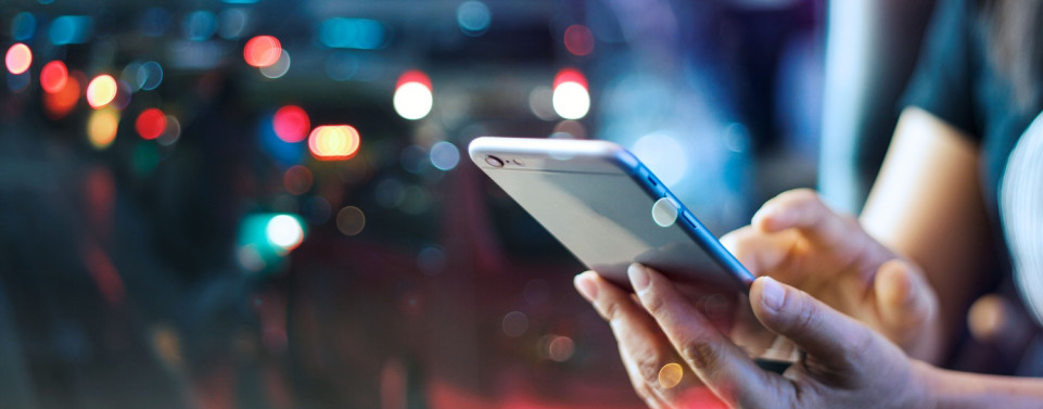 Frau hält Smartphone in der Hand. Symbolbild für Telekommunikationsanbieter.
