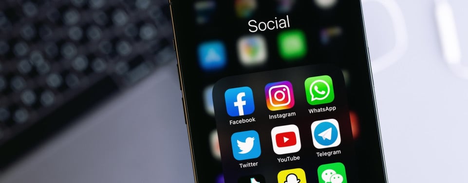 Ein Smartphonedisplay das einen Ordner "Social" zeigt. Dort sind die Apps wie Facebook, Instagram, Whatsapp, Youtube und mehr zu sehen.