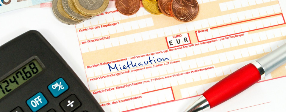 Überweisung mit dem Titel "Mietkaution", Geldmünzen und ein Taschenrechner.