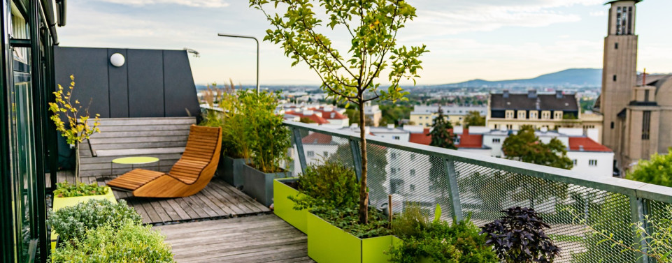 Dachterrasse mit Möbeln und Pflanzen. 