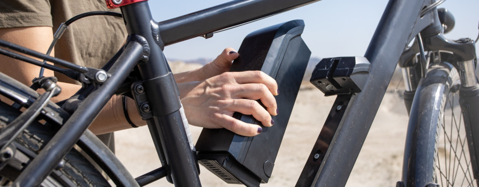Akku von E-Bike wird aus dem Rahmen genommen.