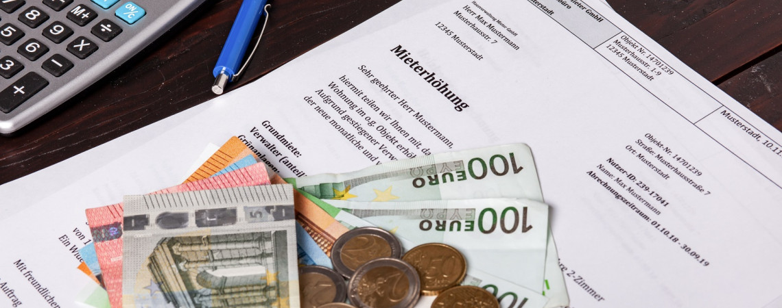 Mieterhöhung Auf einem Tisch liegt ein Schreiben mit dem Betreff "Mieterhöhung". Auf dem Schreiben liegen Geldscheine und Münzen. Oben Links neben dem Schreiben liegt ein Taschenrechner und ein blauer Kugelschreiber.
