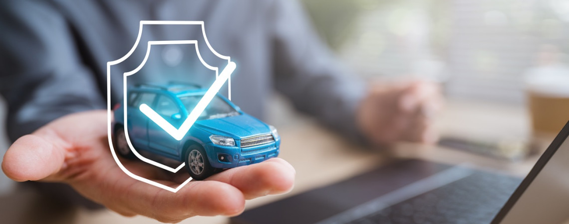 Versicherung für das Auto. Man hält Spielzeugauto hoch, um das ein Schutzschild leuchtet.