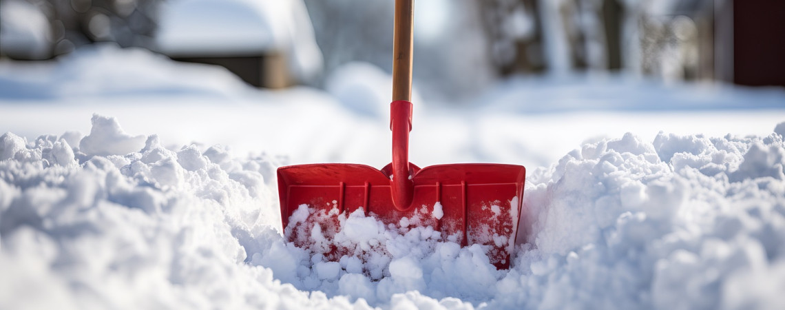 Winterdienst. Rote Schneeschaufel im Schnee