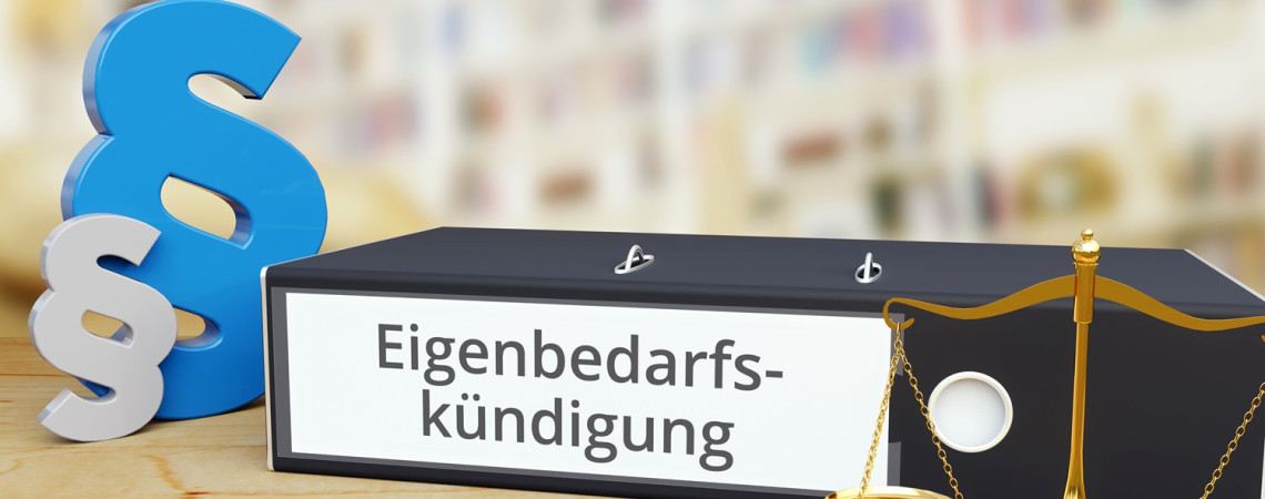 Eigenbedarf. Ein Ordner mit der Aufschrift "Eigenbedarfskündigung" Paragraphenzeichen und eine Waage stehen auf einem Tisch. 