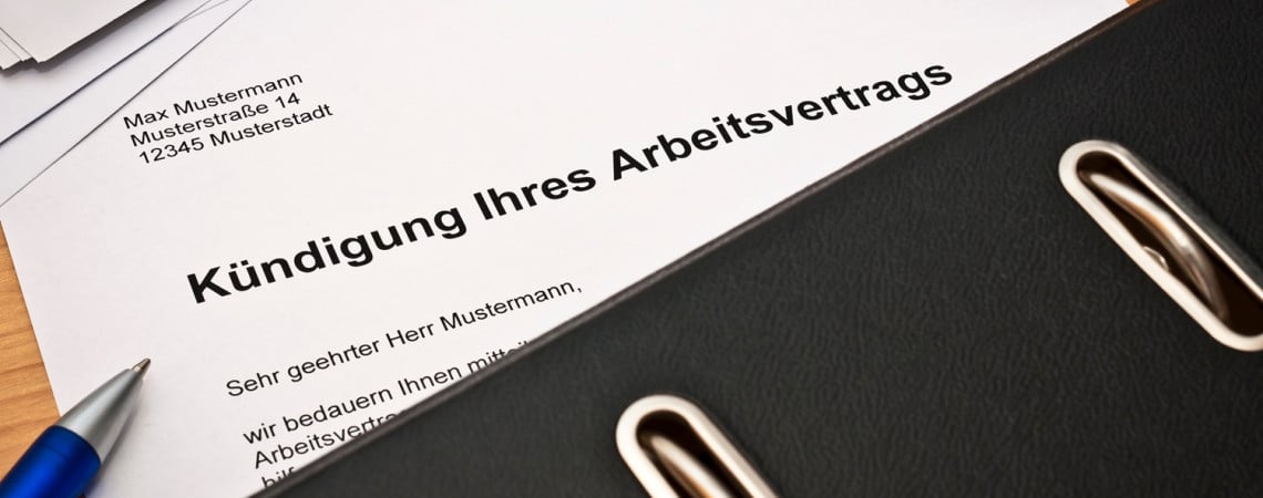 Ein Schriftstück mit der Überschrift "Kündigung Ihres Arbeitsvertrags" liegt auf einen Tisch.