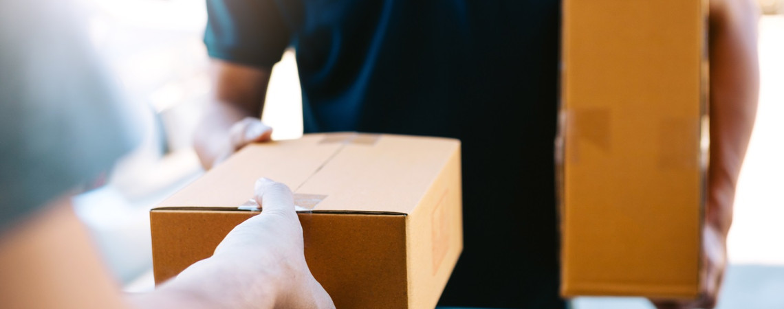 Paketdienst übergibt Paket an eine Person. 