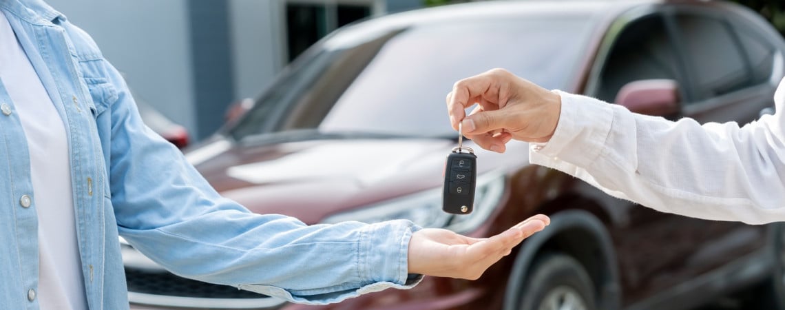 Mann kauf Gebrauchtwagen. Ein Man übergibt Autoschlüssel an den anderen.