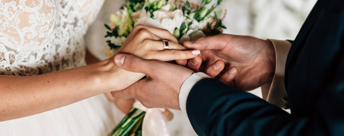 Hochzeitspaar tauscht Eheringe aus.