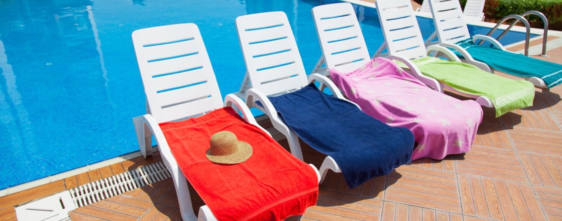 Liegen mit Handtüchern am Pool.