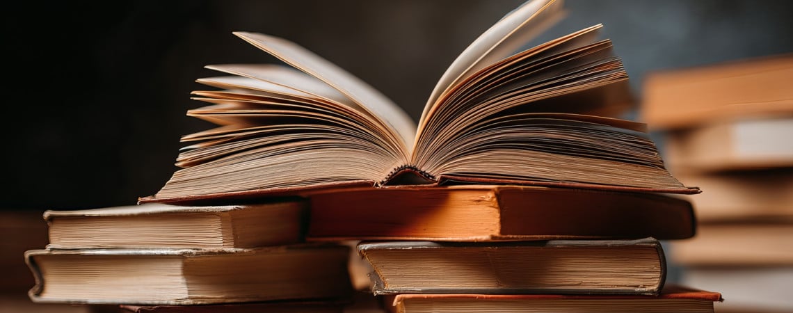 Stabel mit Büchern. Das oberste Buch ist aufgeschlagen. 