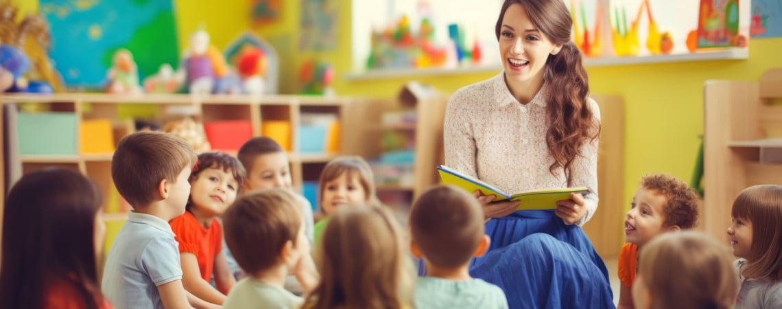 Kinder sitzen auf dem Boden und Kindergärtnerin ließt ihnen ein Buch vor.
