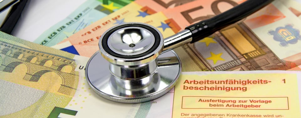 Krankengeld. Geldscheine, auf denen ein Stethoskop und eine Arbeitsunfähigkeitsbescheinigung liegt.  