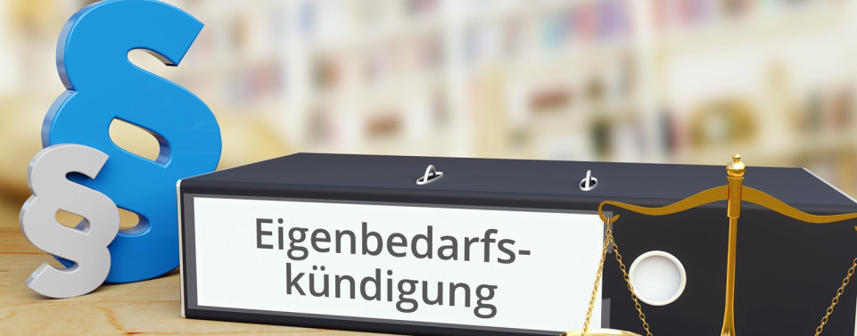 Eigenbedarf. Ein Ordner mit der Aufschrift "Eigenbedarfskündigung" Paragraphenzeichen und eine Waage stehen auf einem Tisch. 
