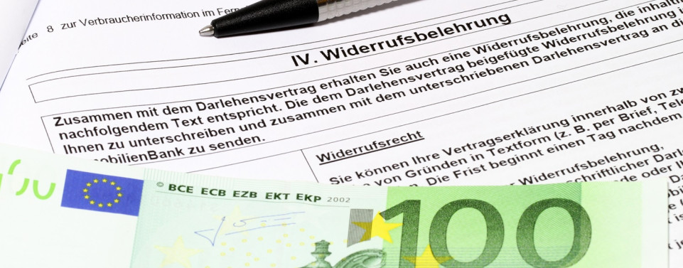 Ein beschriftetes Papier mit der Überschrift "Widerrufsbelehrung" und ein Stift. Am linken unteren Rand sieht man einen 100-Euro-Schein.