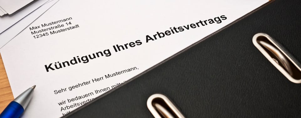 Ein Schriftstück mit der Überschrift "Kündigung Ihres Arbeitsvertrags" liegt auf einen Tisch.