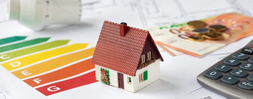 Modellhaus mit Energiepass, Geld und ein Heizungsthermostat - Energieberatung. 