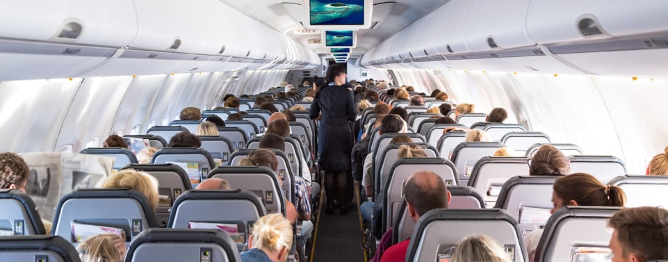 Flugzeug mit Sitzreihen, in denen Menschen sitzen.